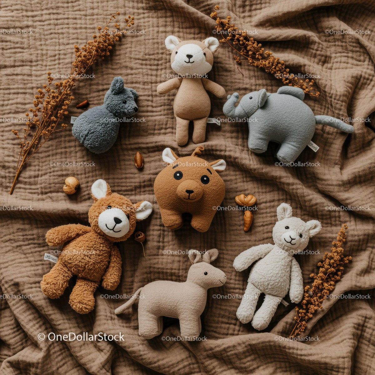 Soft animal plush toys arranged on warm fabric background