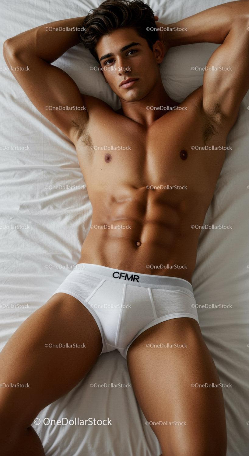 Athletic man relaxing on bed in white briefs
