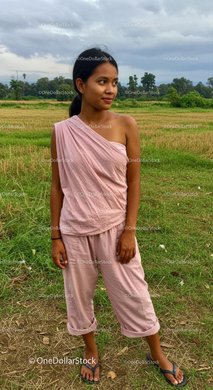 Young Woman in Pink Sari Standing Outdoors in Rural Green Fields