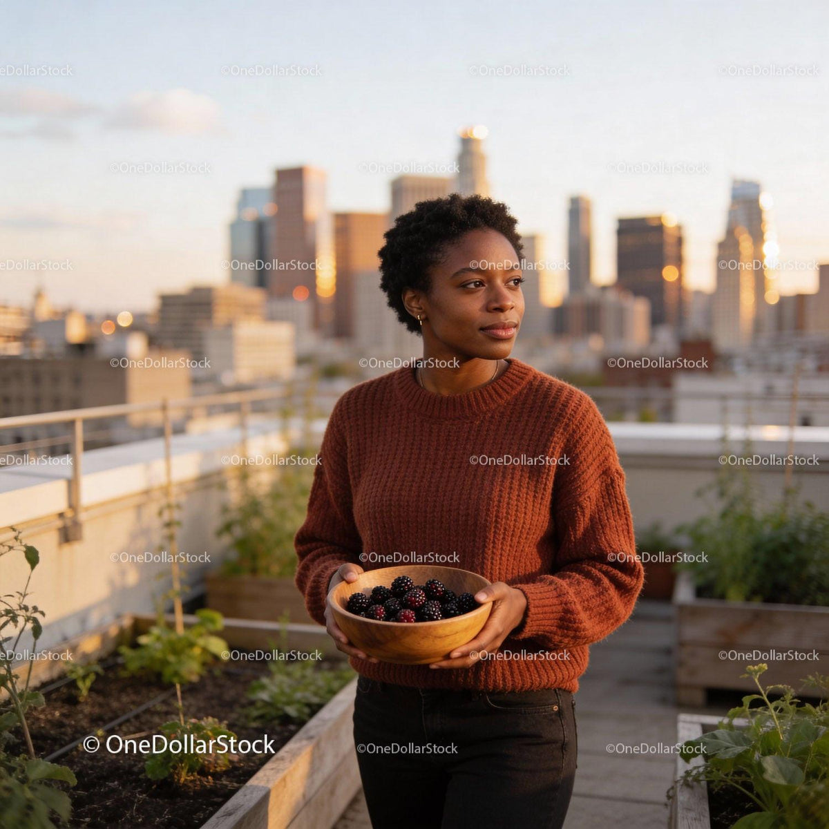 Woman holding fresh blackberries in urban rooftop garden