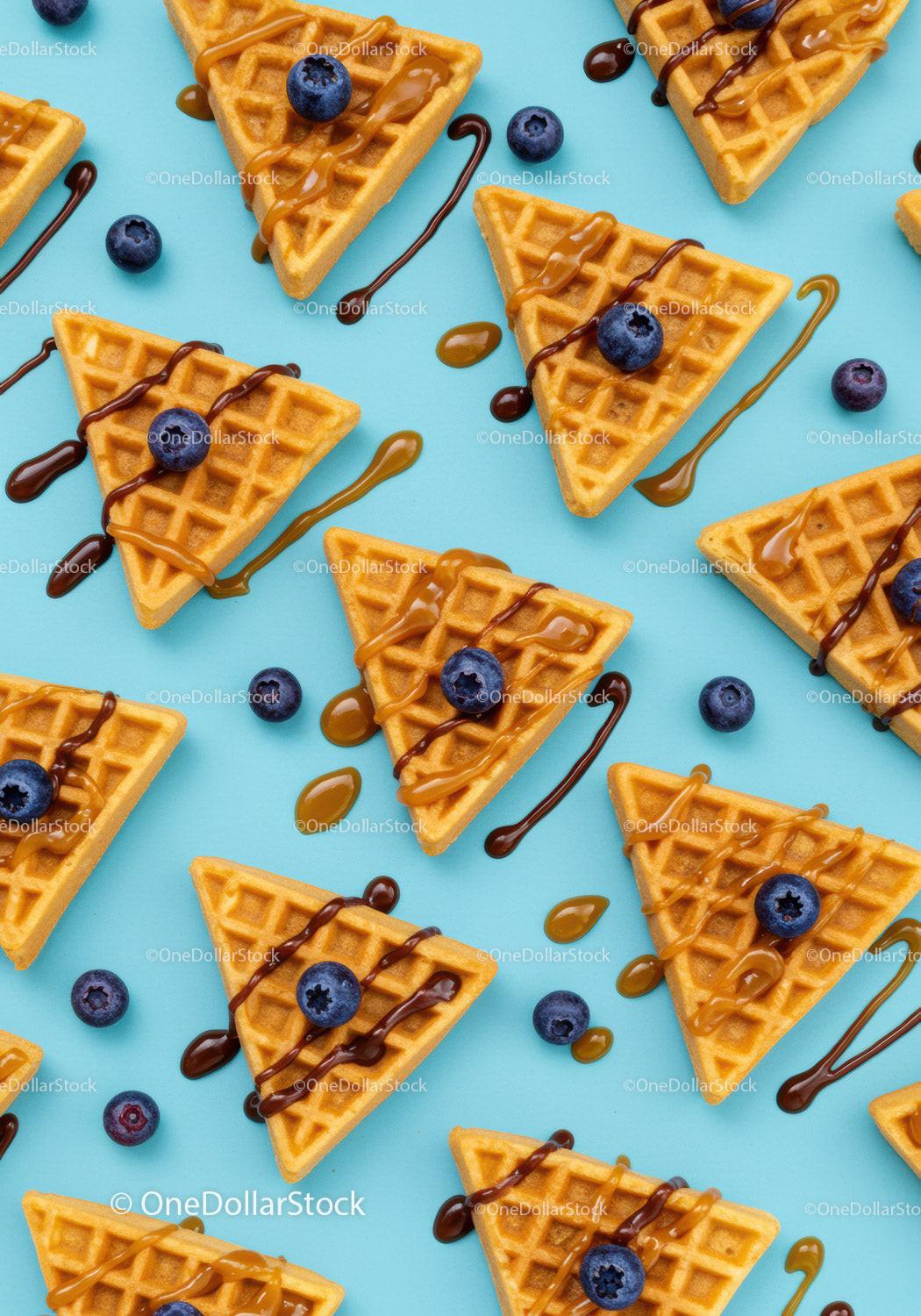 Golden waffles with blueberries and drizzled sauces