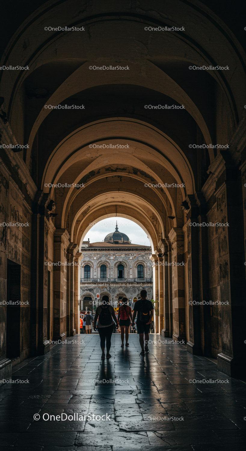 Historic Archway with Tourists and City Skyline Backdrop