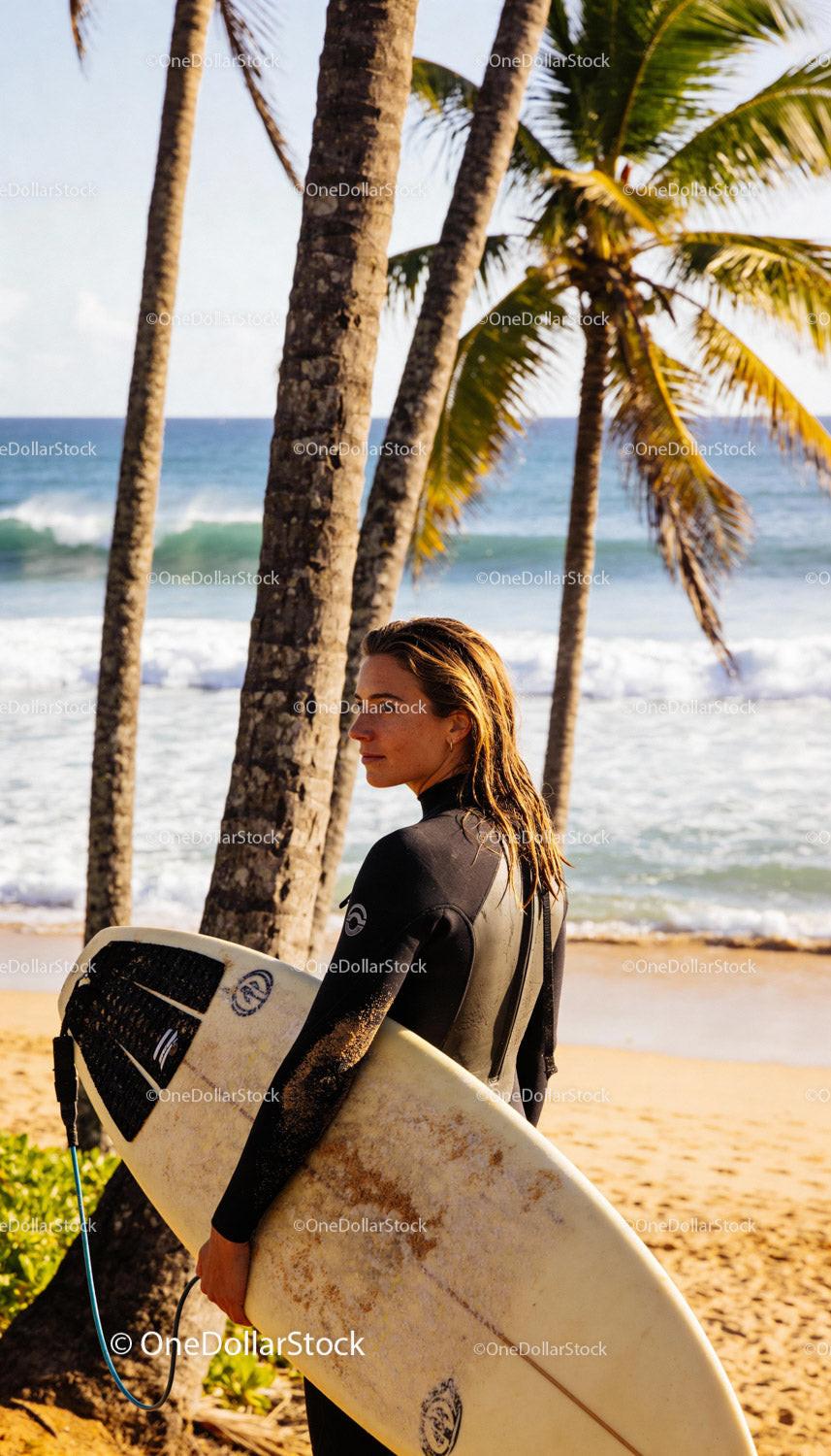 Woman Surfer Standing on Tropical Beach Holding Surfboard