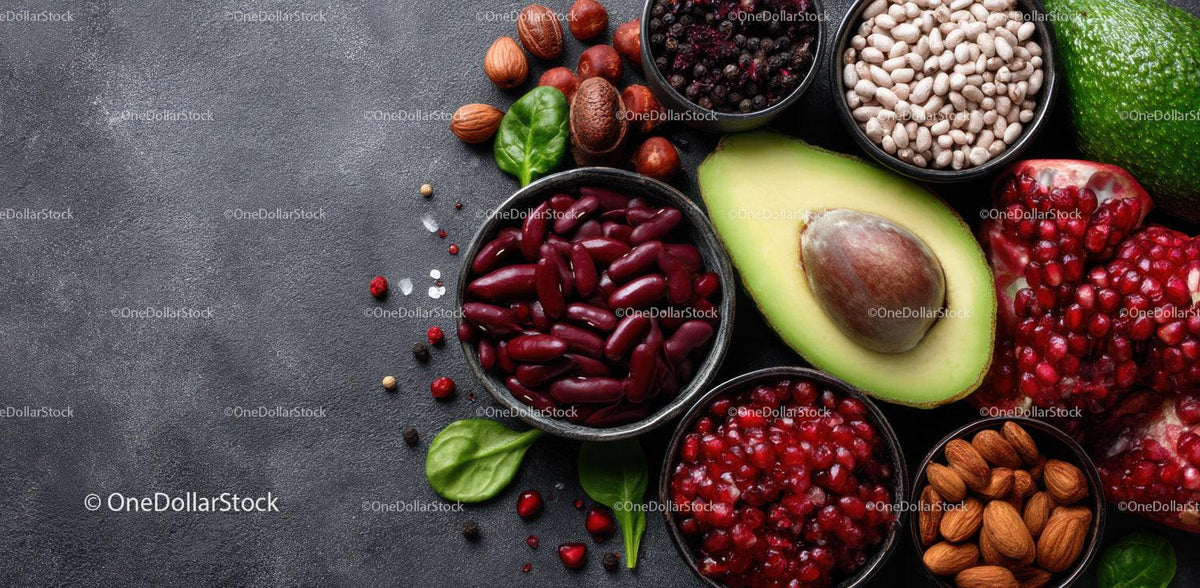 Assorted Fresh Fruits and Nuts with Avocado and Berries on Dark Surface