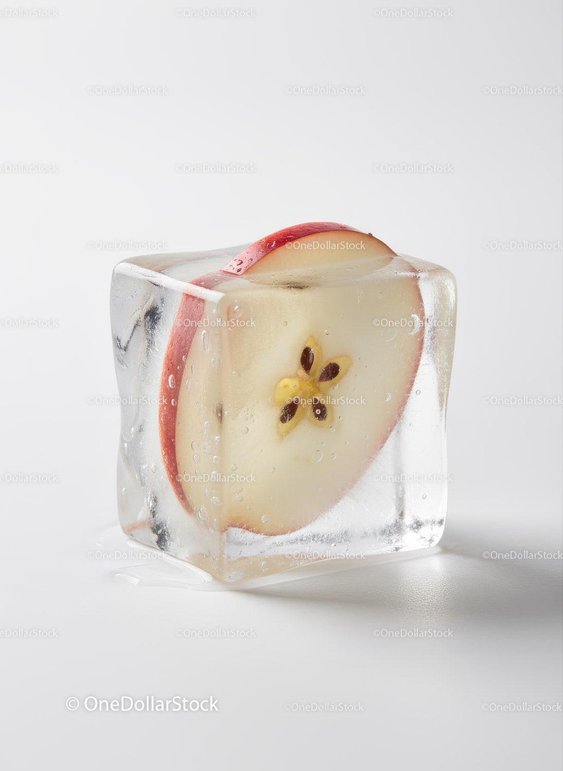 Fresh apple slice frozen inside a clear ice cube