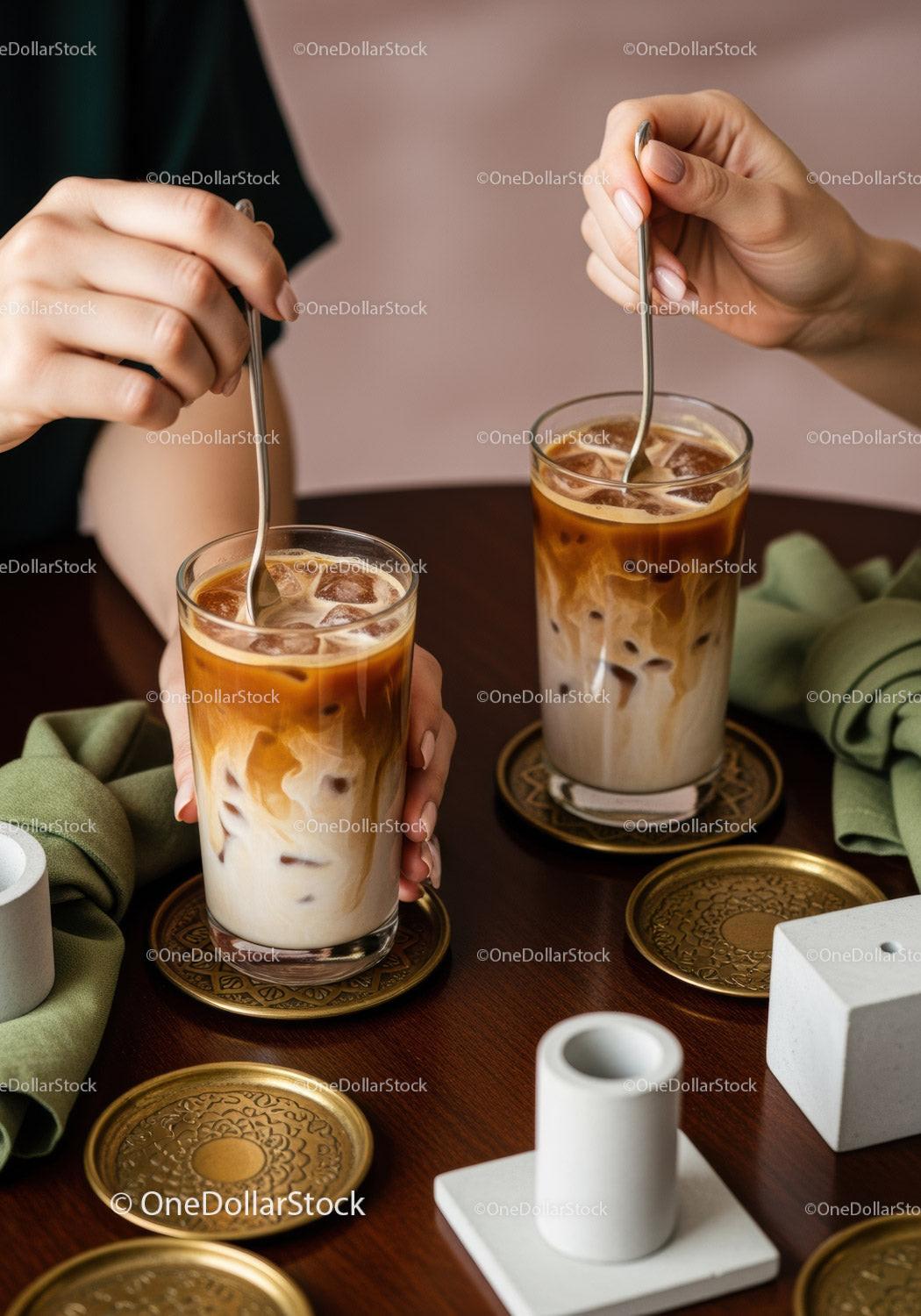 Iced Coffee with Milk and Ice Cubes on Wooden Table with Gold Coasters