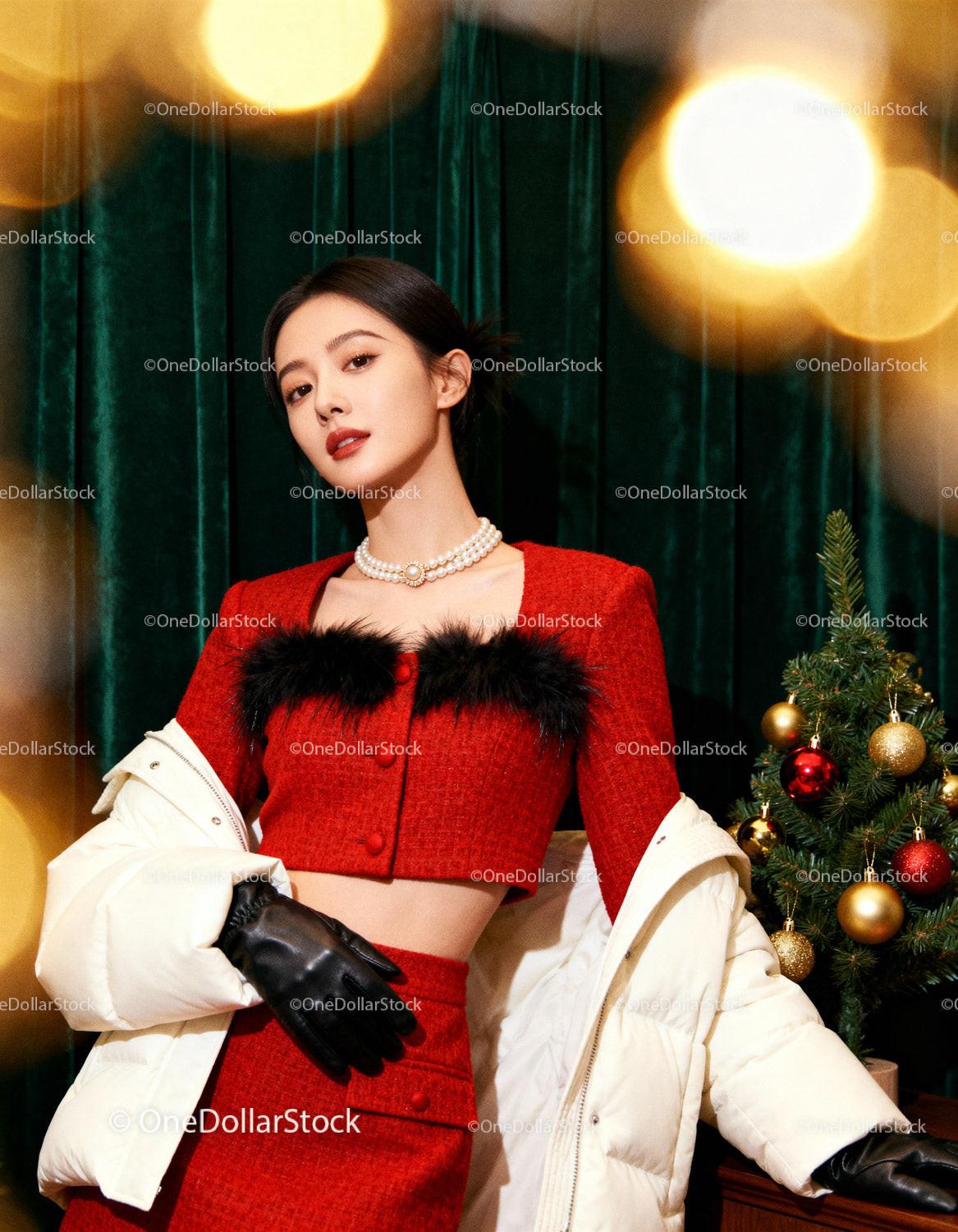 Elegant woman in festive red outfit by Christmas tree