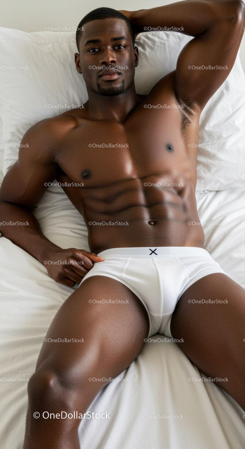 Relaxed muscular man lying on white bed in underwear