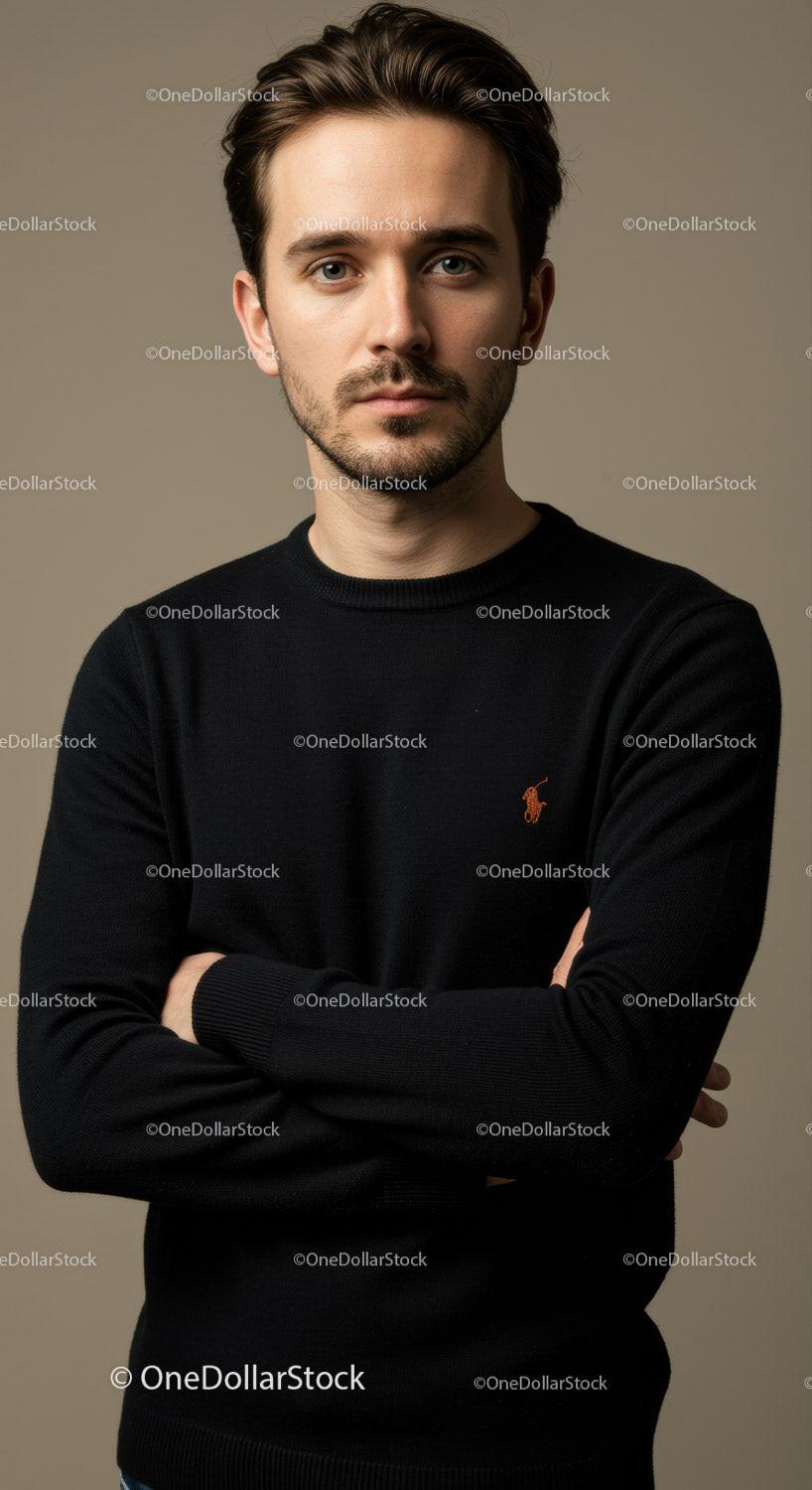 Thoughtful young man posing with crossed arms indoors