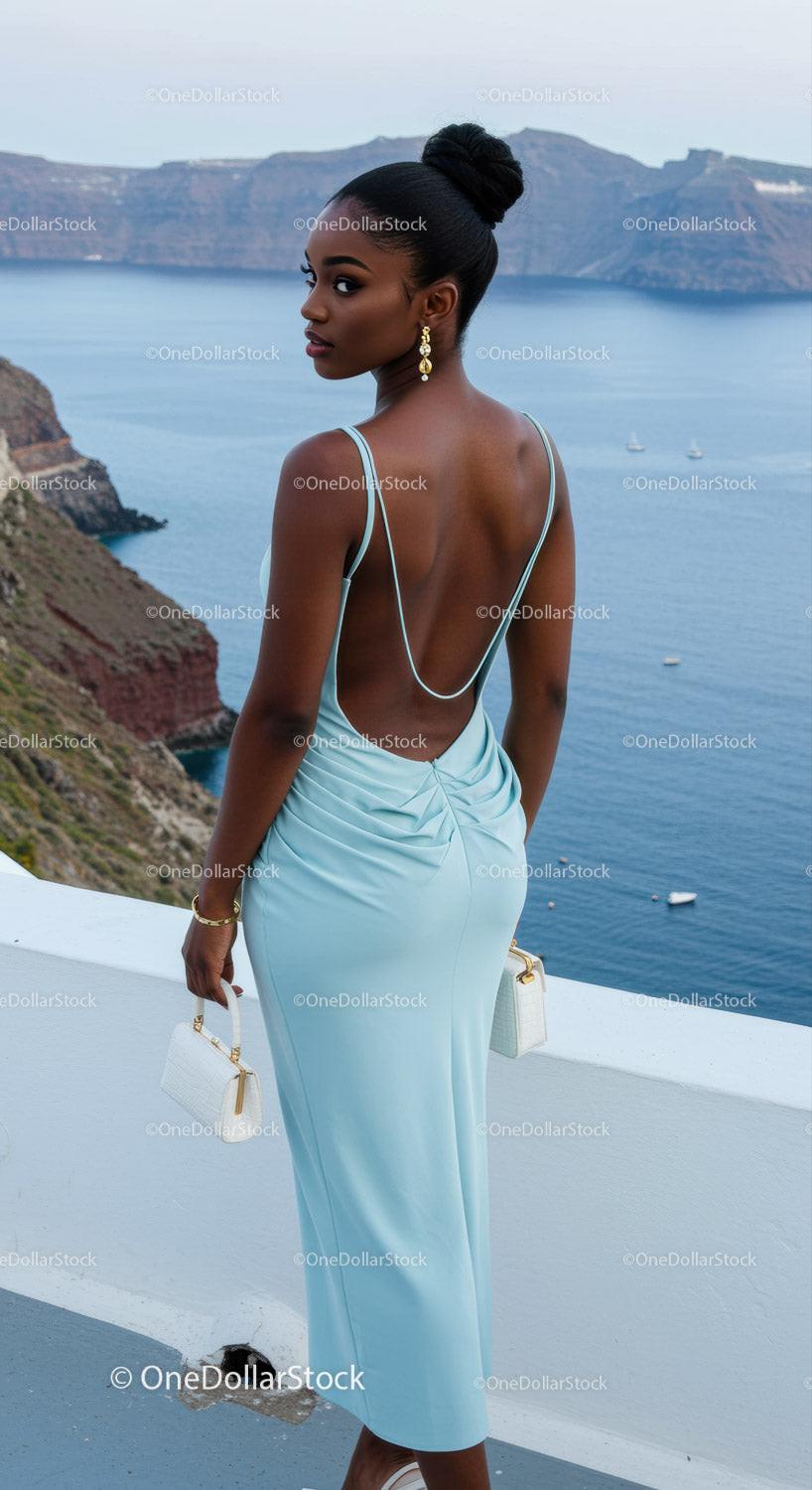Elegant woman in blue dress overlooking sea cliff