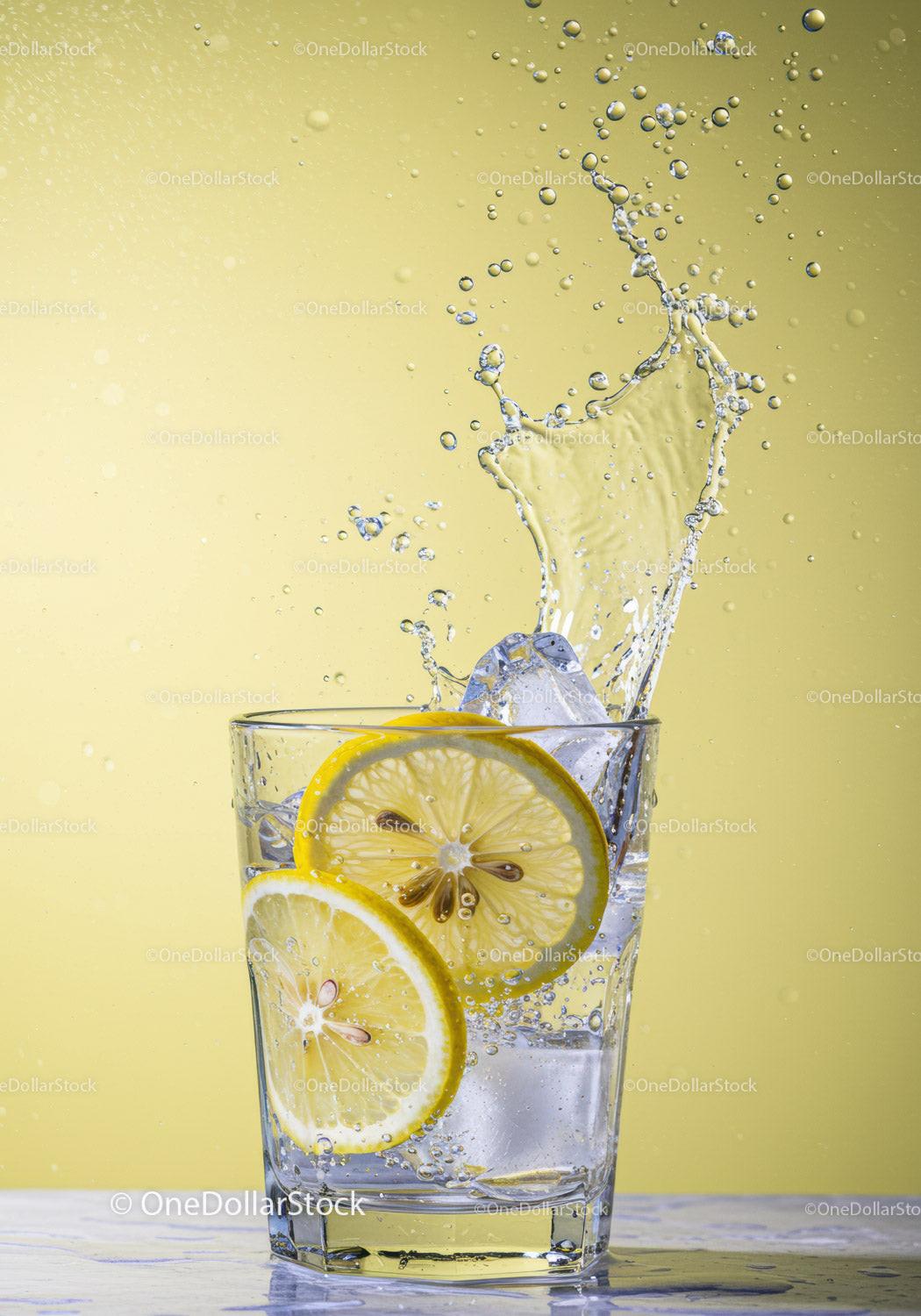 Fresh Lemon Slices Splashing Into Glass of Water