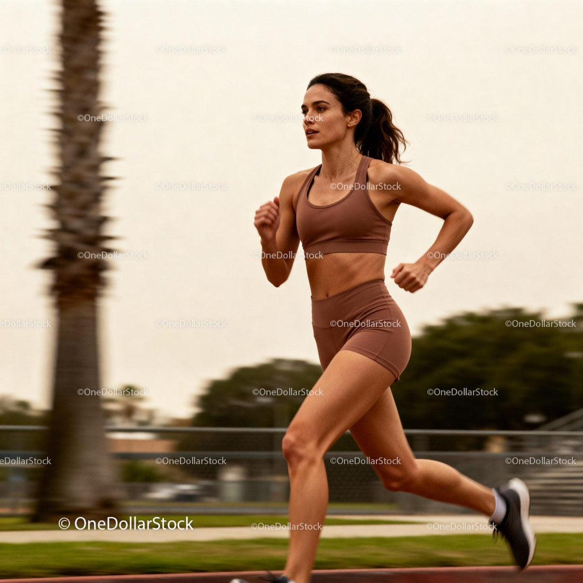Focused young woman running outdoors at sunset