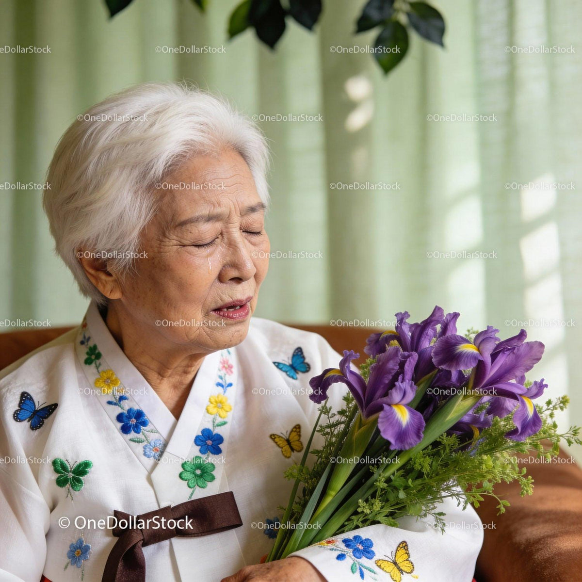Elderly woman in traditional dress holding irises with tears