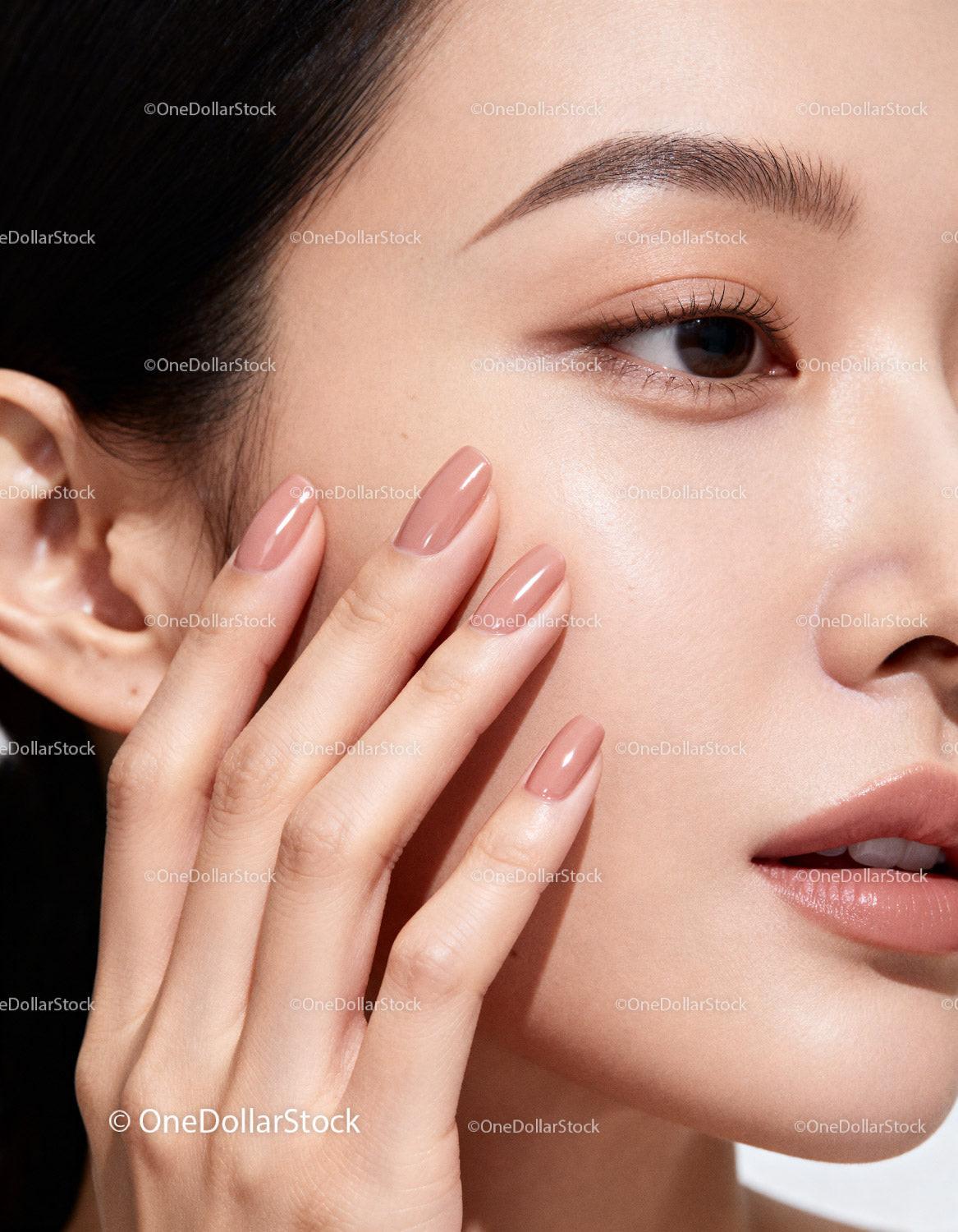 Close-up of woman with smooth glowing skin and manicured nails