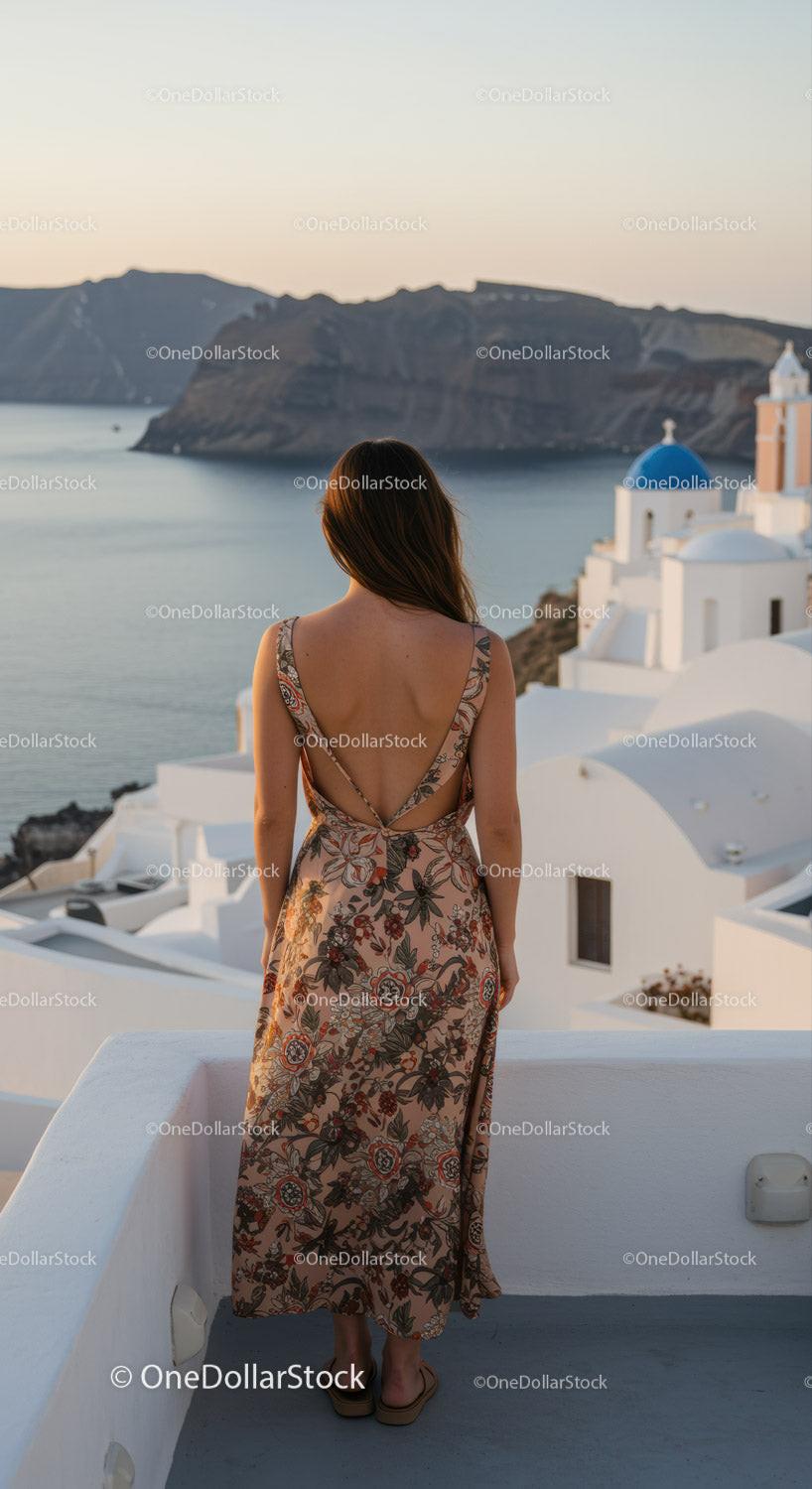 Woman in floral dress overlooking Santorini sea view