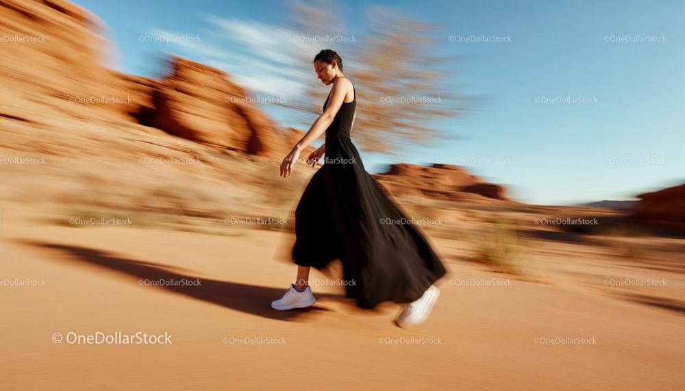 Elegant Woman in Black Dress Walking Through Desert Scene