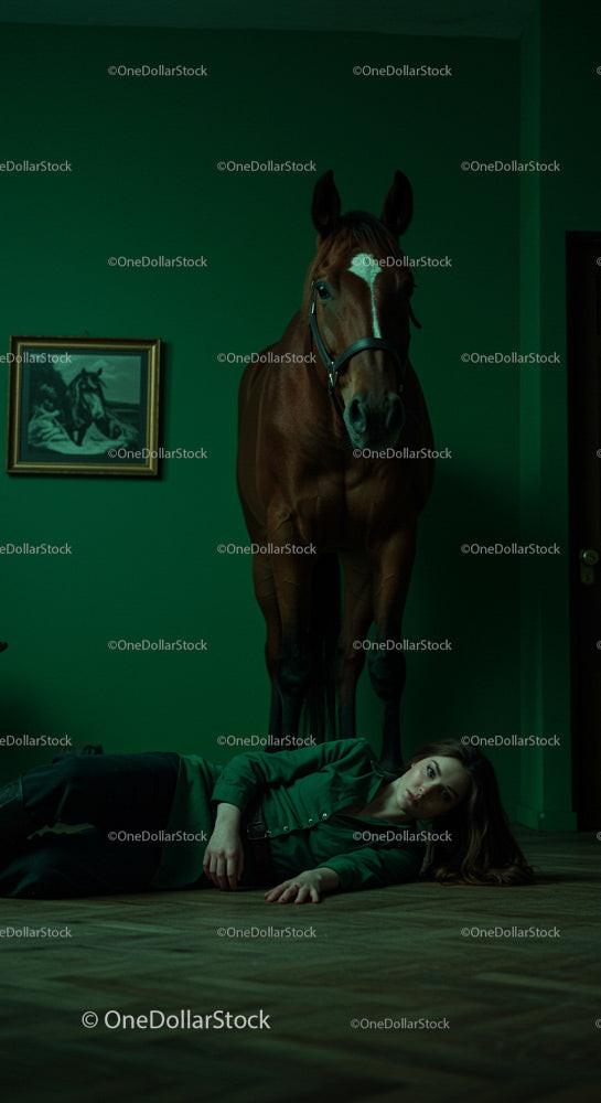 Horse Standing Over Woman in Dark Green Room