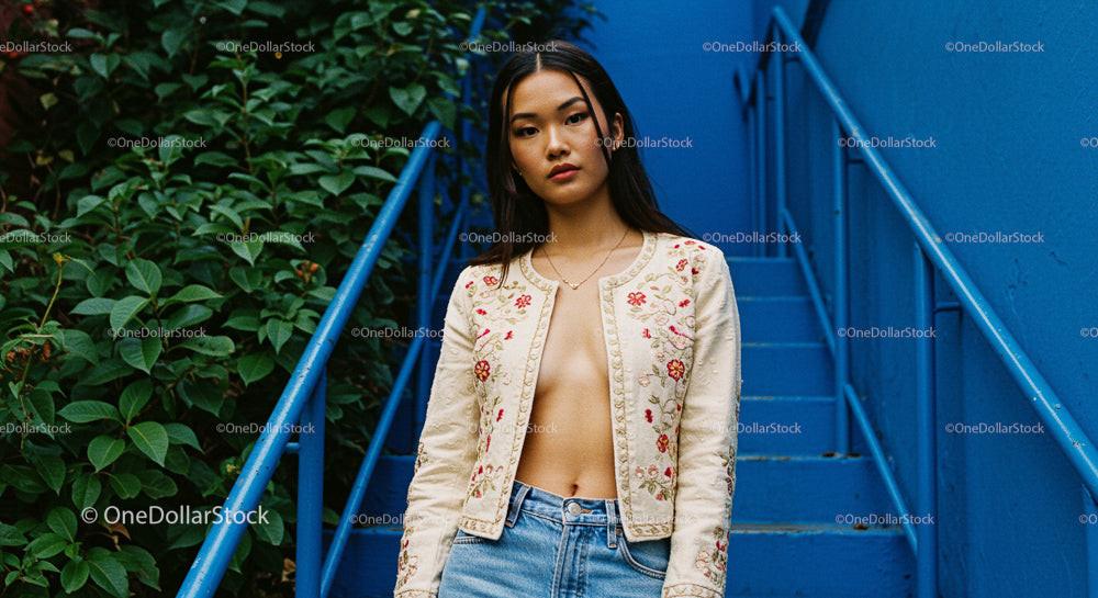 Stylish Woman in Embroidered Jacket on Blue Urban Stairs