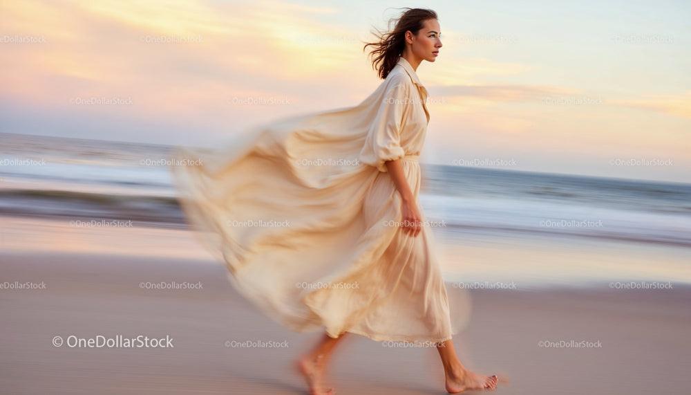 Elegant Woman in Flowing Dress Strolling Along the Beach