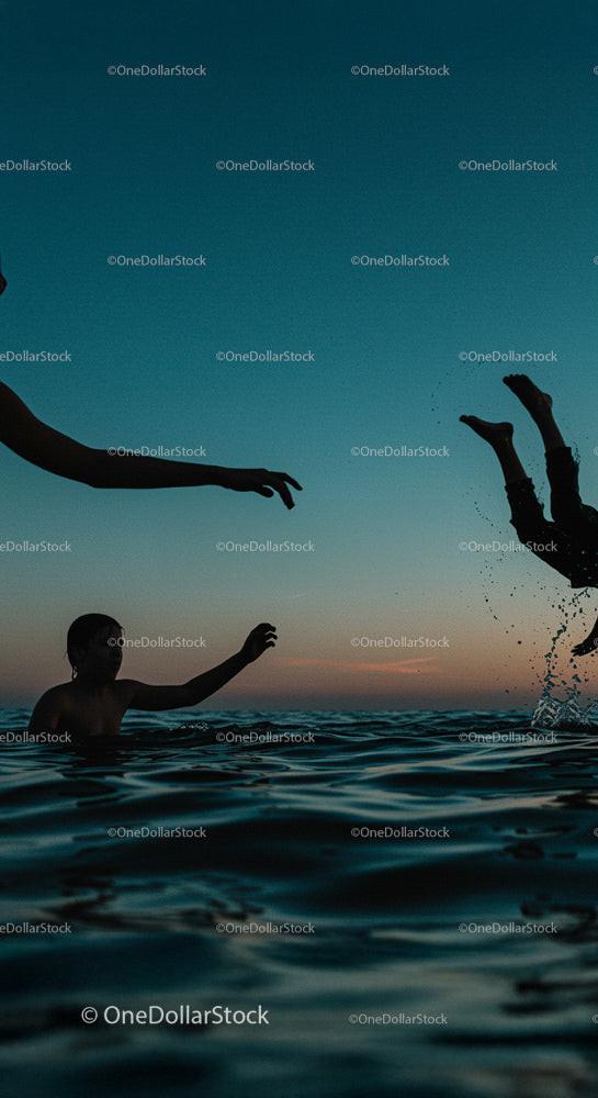 Children Playing in Water at Sunset Silhouette