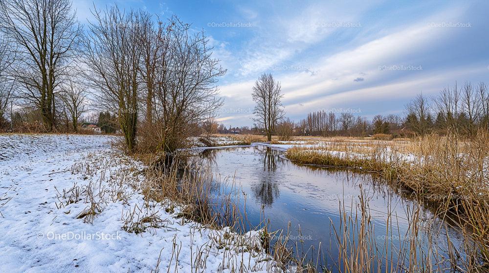 Serene Winter Landscape with Snow and Reflective Stream