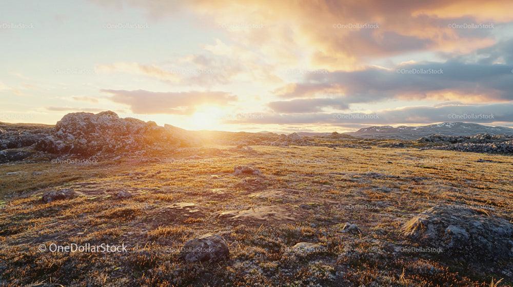 Golden Hour Over Rocky Terrain with Dramatic Sky