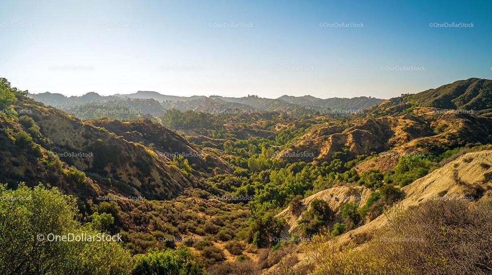 Scenic Rolling Hills with Lush Greenery Under Clear Blue Skies
