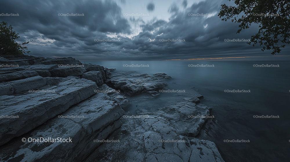 Dramatic Rocky Shoreline Under Stormy Evening Skies