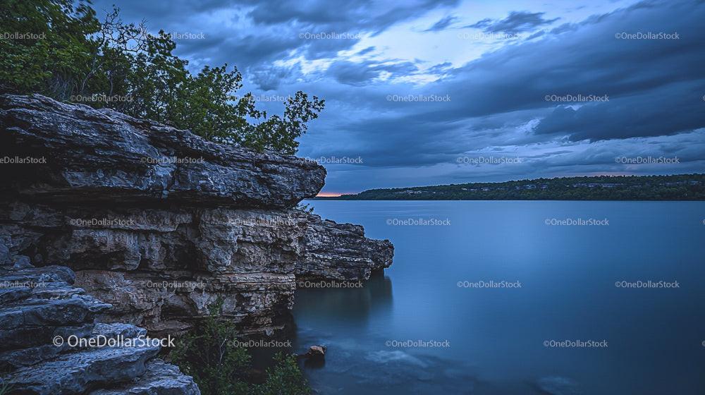 Dramatic Cliffside Overlooking Tranquil Lake at Dusk