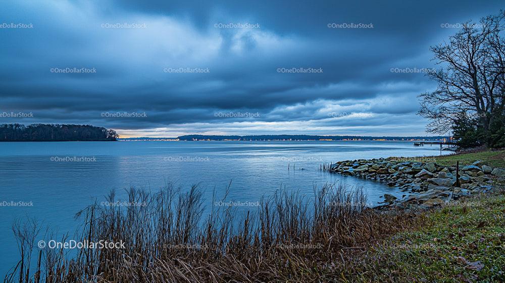 Stormy Sky Over Tranquil Lake with Natural Shoreline