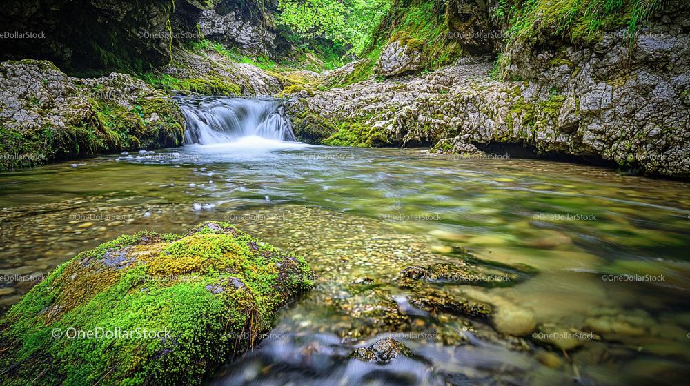 Serene Waterfall Flowing Through Moss Covered Rocks
