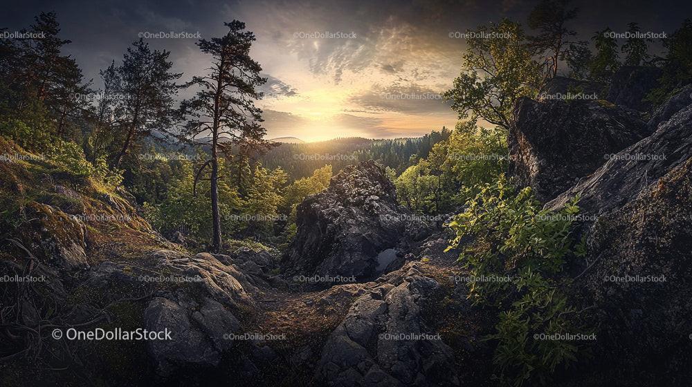 Dramatic Sunset Over Rocky Forest Landscape