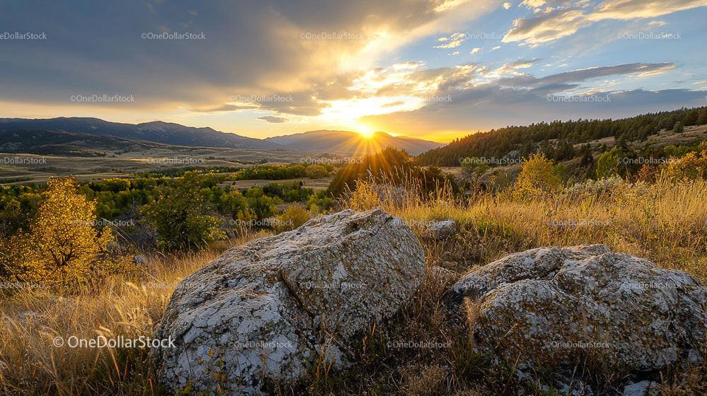 Breathtaking Sunset Over a Mountain Valley with Rocks in Foreground