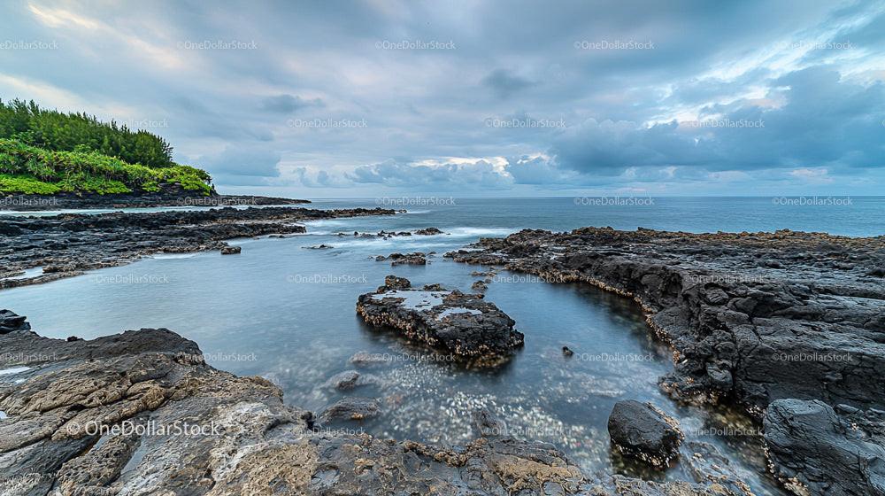 Dramatic Rocky Coastline with Serene Ocean and Clouds