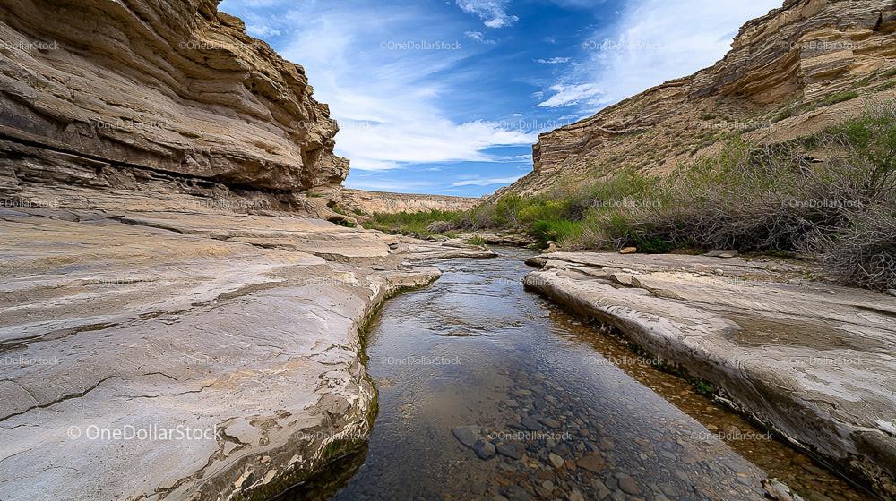 Serene Rocky Canyon with Stream and Sandstone Cliffs