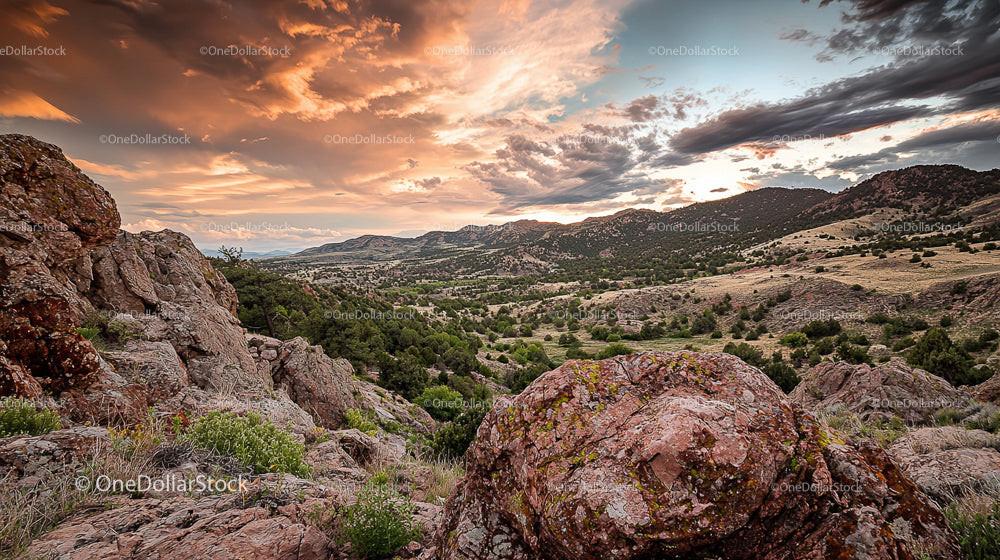 Dramatic Sunset Over Rocky Hills and Expansive Wilderness