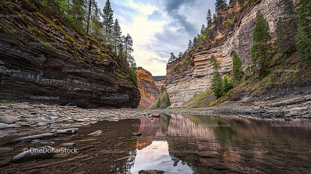 Scenic Canyon and River Reflection Under Cloudy Skies