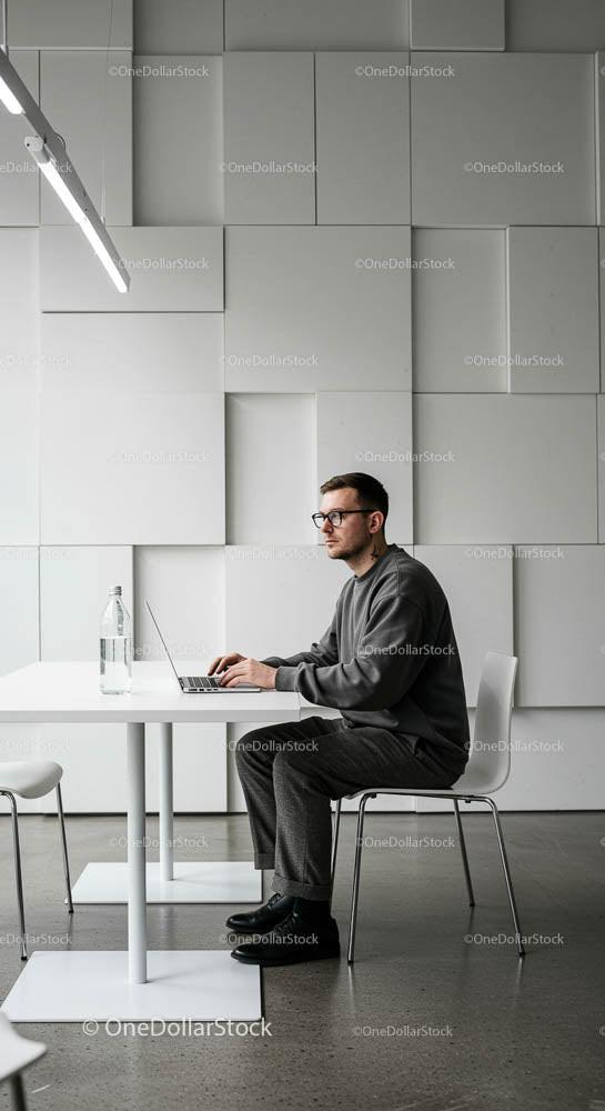 Man Working on Laptop in Minimalist Modern Office
