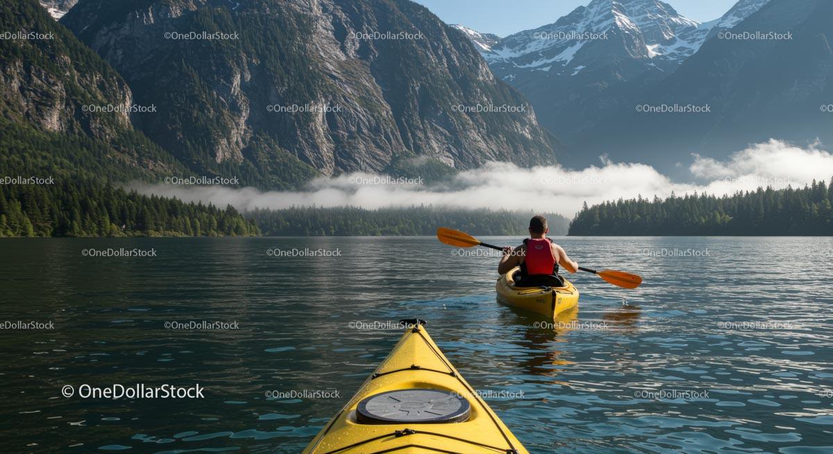 Kayaker Exploring Serene Mountain Lake with Misty Peaks