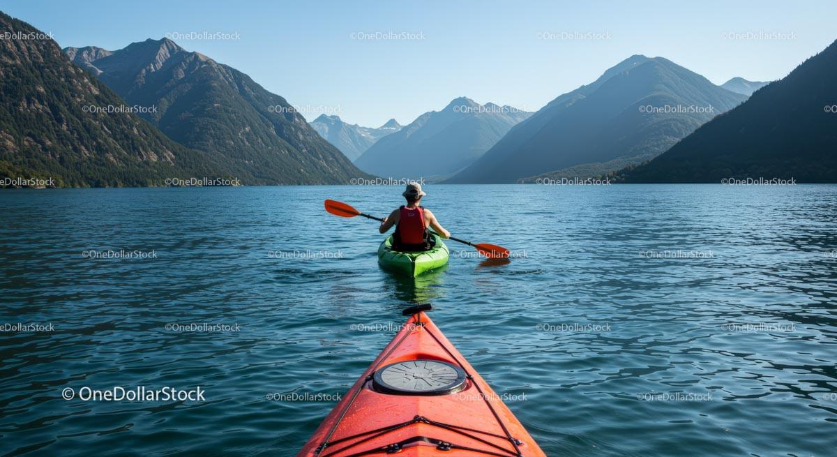 Kayaker Exploring Tranquil Mountain Lake Amidst Majestic Peaks