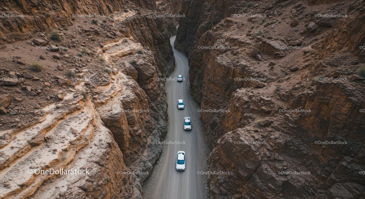 Aerial View of Cars Navigating a Rocky Desert Canyon