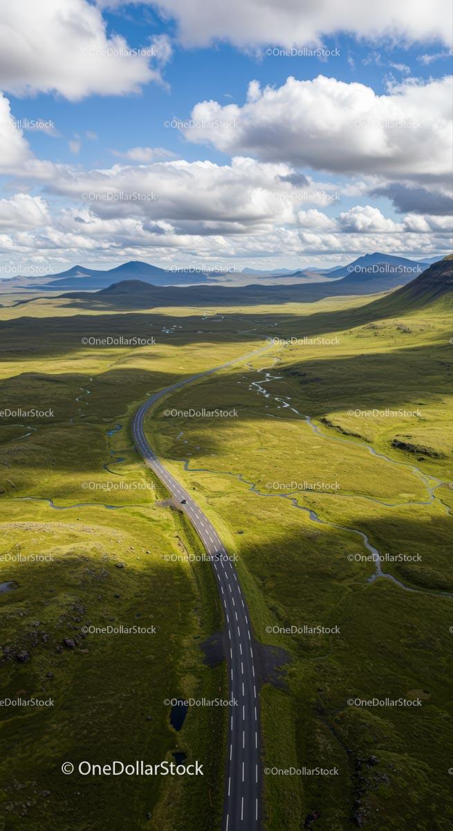 Scenic Road Through Vast Green Highlands Under Blue Sky