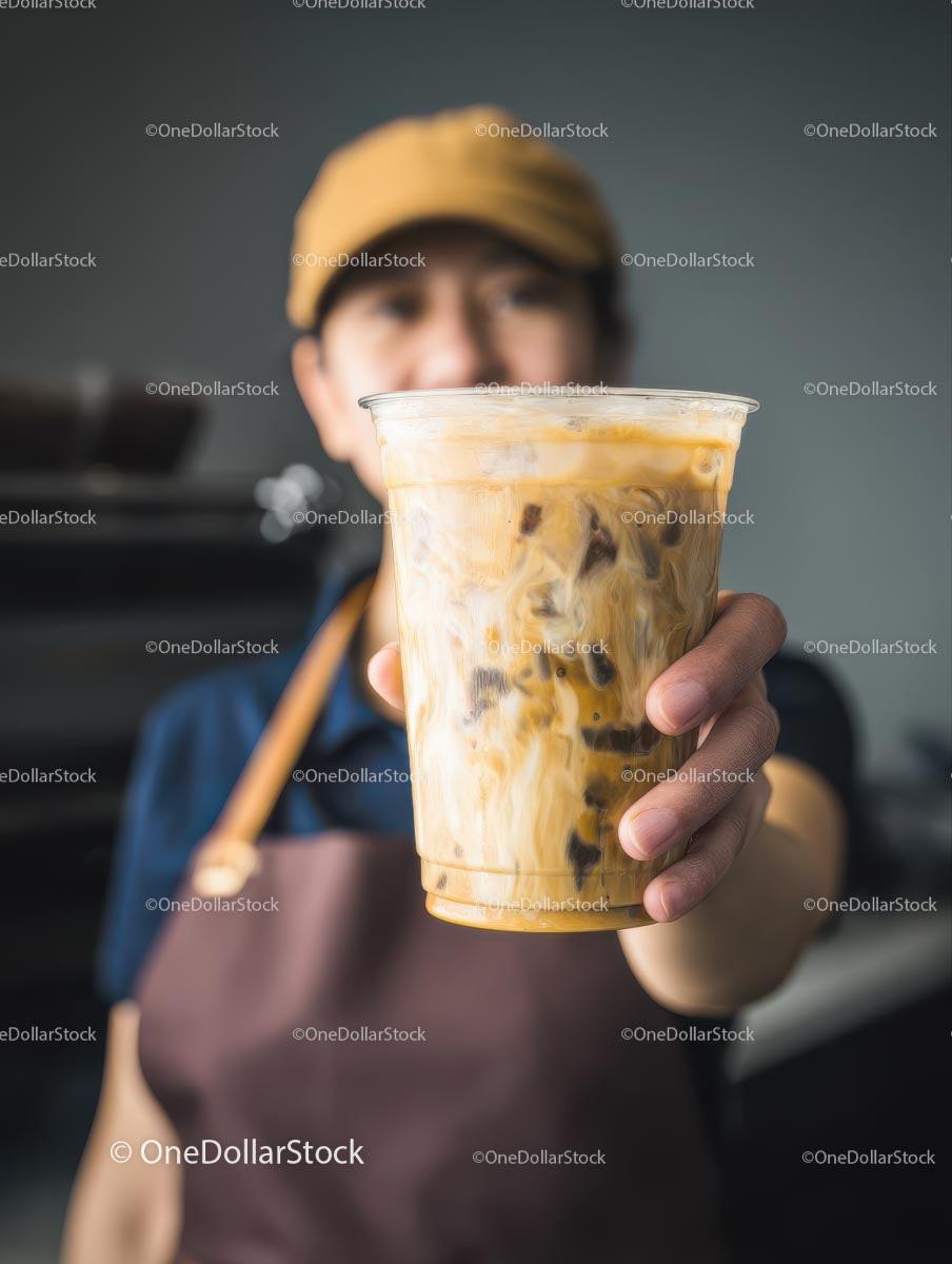 Barista Offering Iced Coffee in a Plastic Cup
