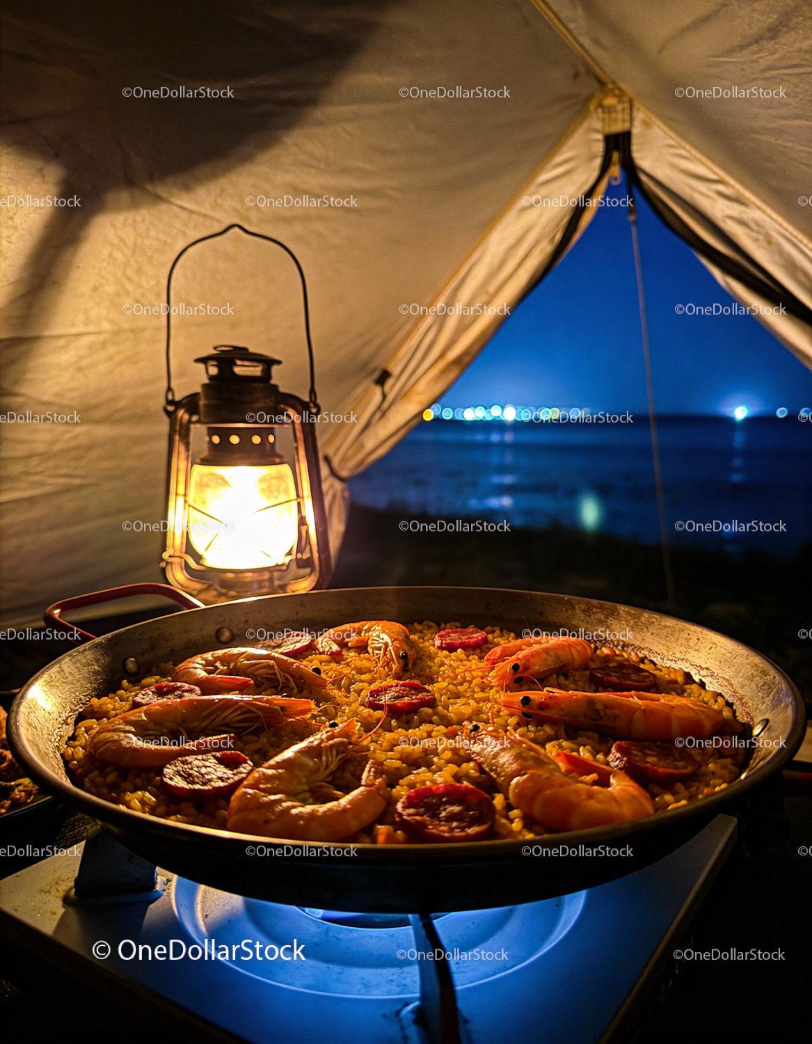 Seafood paella cooking over camp stove at night