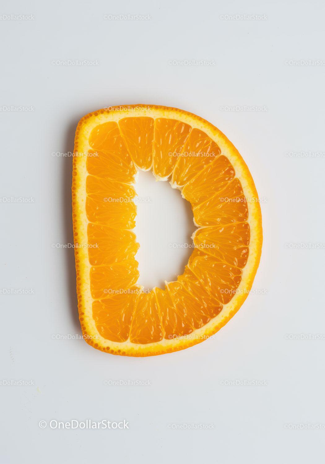 Fresh orange slice shaped like letter D on white background