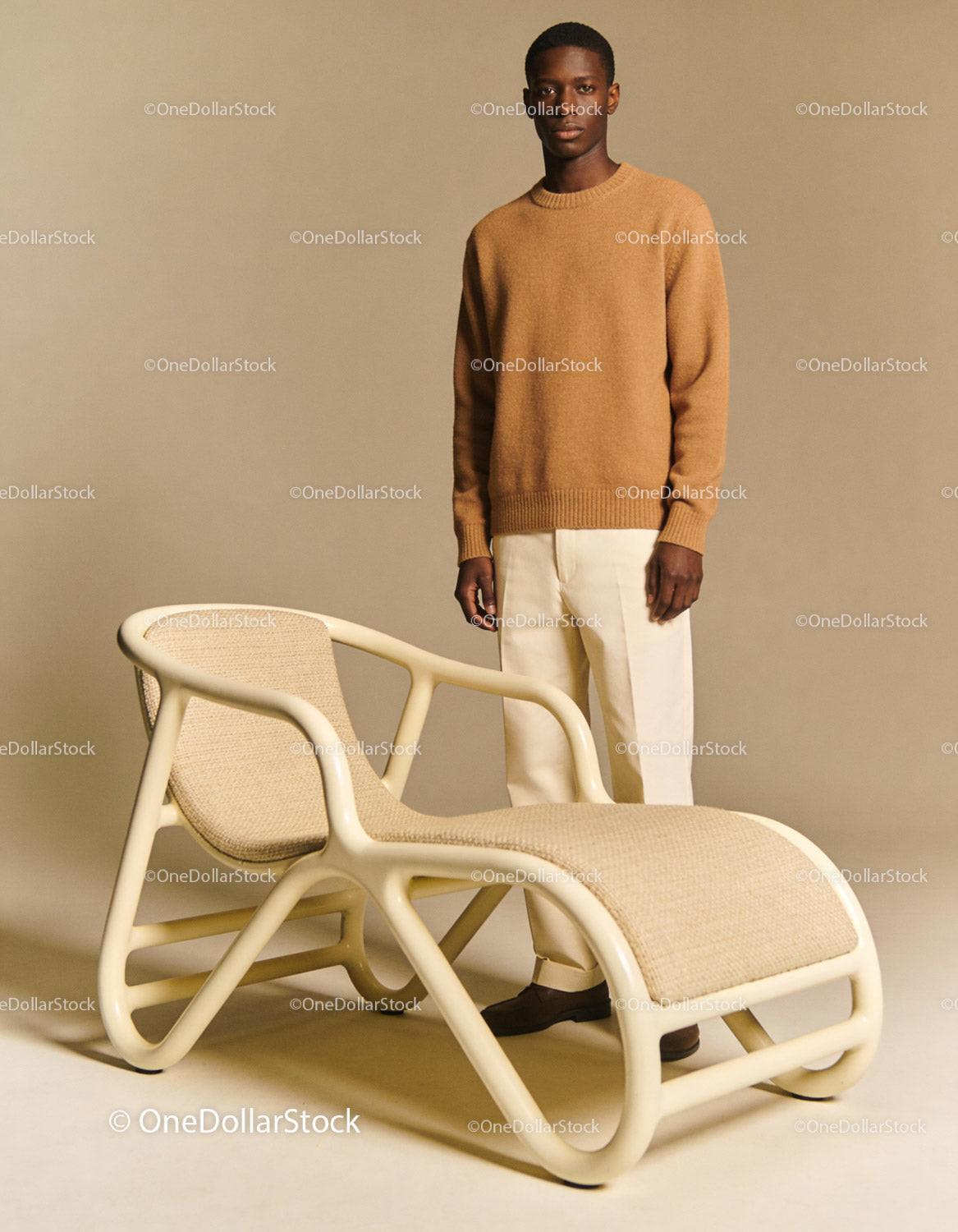 Man in cozy sweater standing beside modern lounge chair
