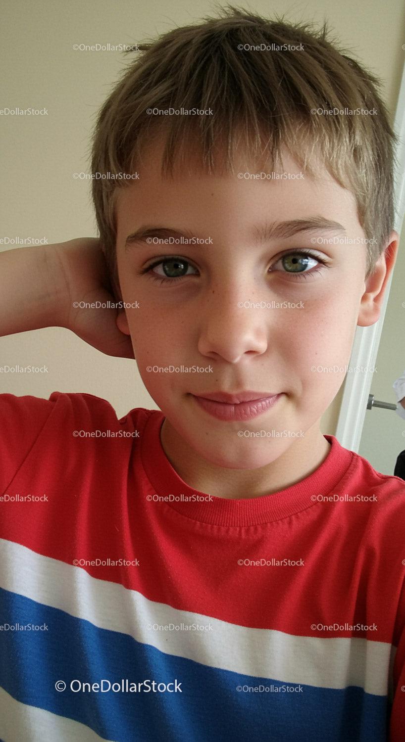 Close-up of a smiling boy with green eyes and light brown hair