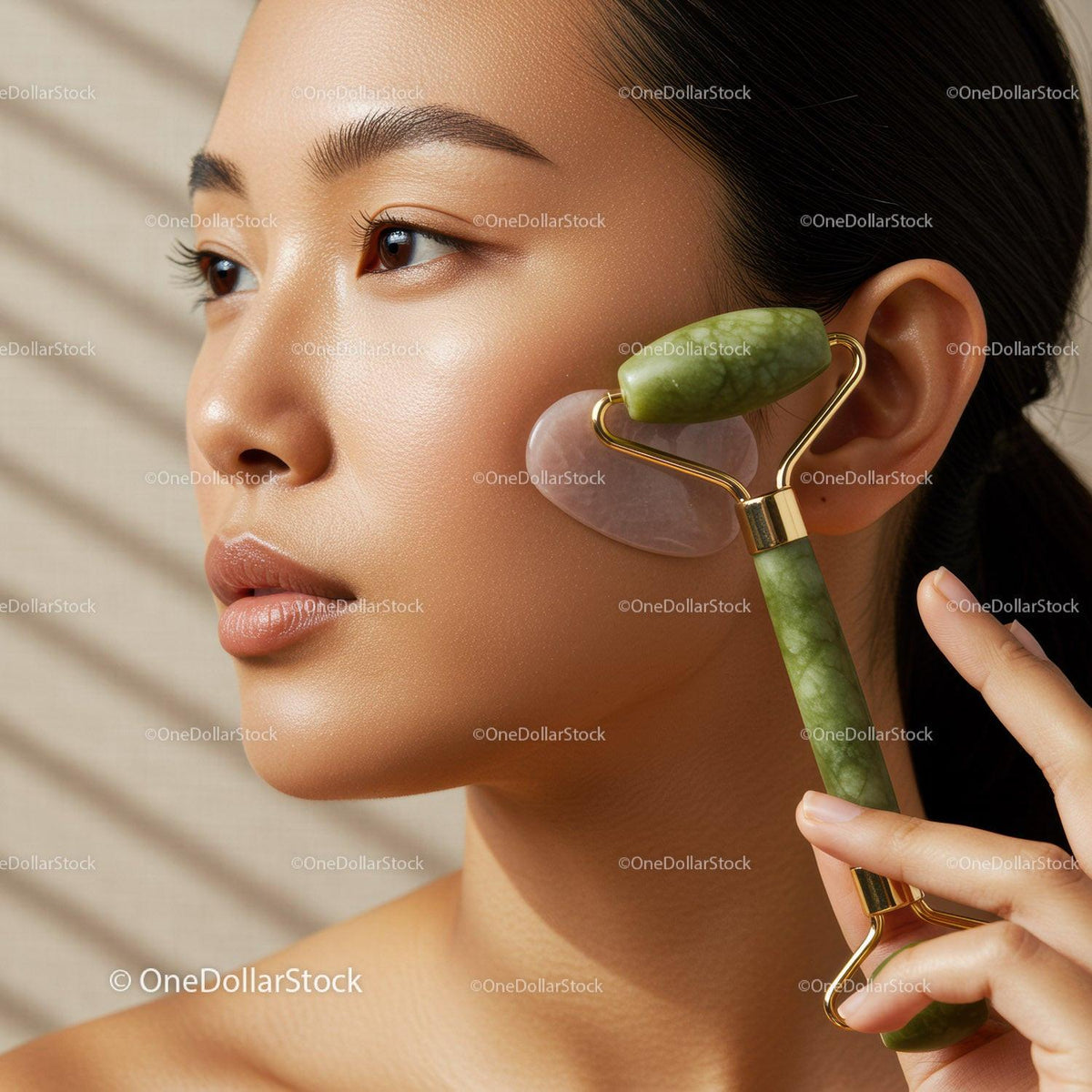 Close-up of Young Asian Woman Using Jade Roller for Facial Massage