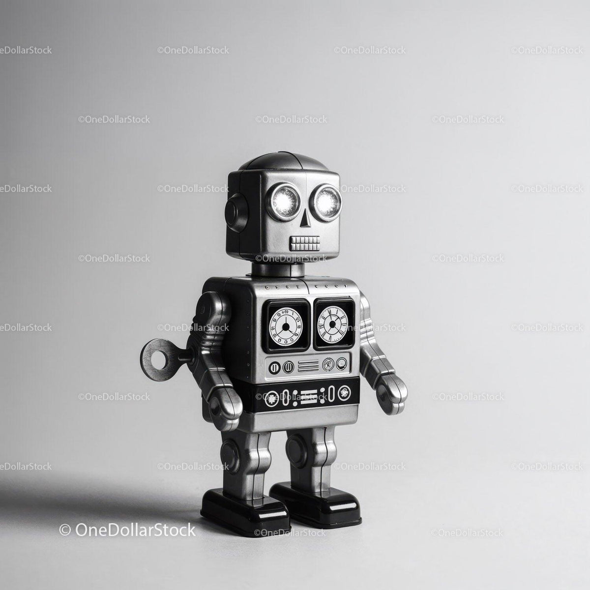 Silver metallic toy robot with clock dials on chest and wind-up key on side