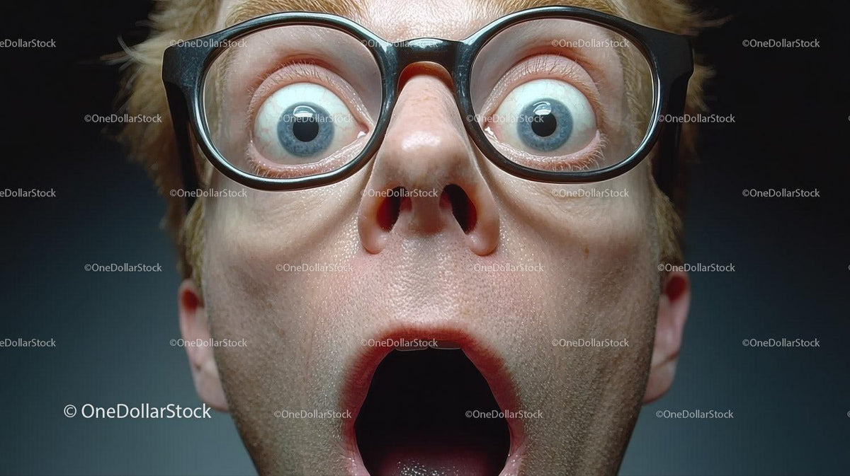 Surprised man wearing round glasses with wide eyes and open mouth closeup